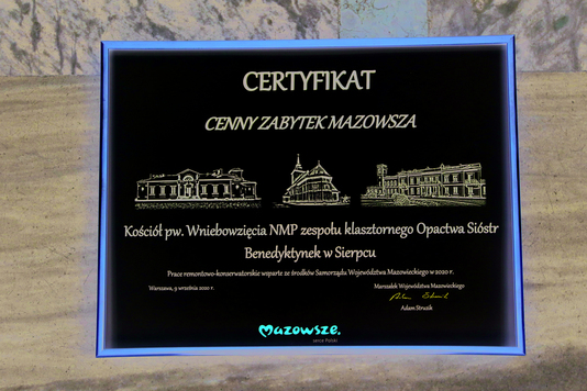 tabliczka z napisem certyfikat cenny zabytek Mazowsza, rysunkami obiektów sakralnych i nazwą zabytku