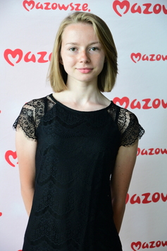 zdjęcie portretowe dziewczyny, w tle ścianka z napisem Mazowsze