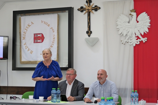 Przy stole prezydialnym od lewej: stoi radna Jadwiga Zakrzewska, siedzą przewodniczący komisji Leszek Przybytniak, radny Piotr Kandyba