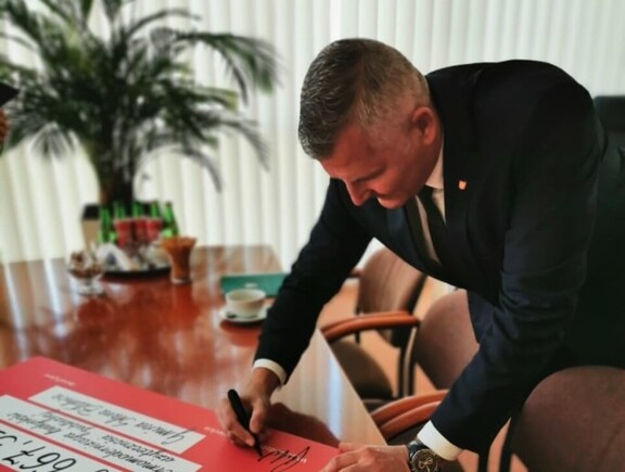 Wicemarszałek Rafał Rajkowski podpisuje symboliczny czek