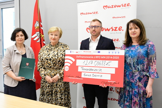 Członkinie zarządu województwa mazowieckiego Elżbieta Lanc i Janina Ewa Orzełowska przekazują  czek wójtowi gminy Czarnia