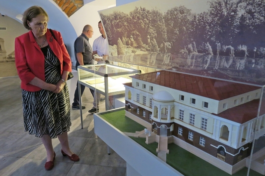 Przewodnicząca komisji Jadwiga Zakrzewska ogląda makietę pałacu znajdującą się w przestrzeni muzealno-wystawienniczą w piwnicy Domku Ogrodnika.