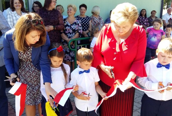 Dwie członkinie zarządu województwa mazowieckiego wspólnie z trzema przedszkolakami przecinają wstęge na otwarciu przedszkola w Łochowie po modernizacji