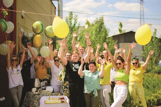 grupa osób z żółtymi balonami pozuje do zdjęcia 