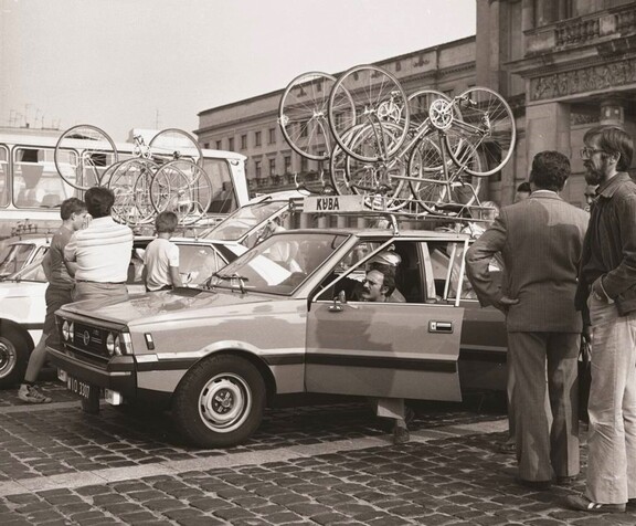 Polonez (auto) z rowerami na dachu przed Pałacem Kultury