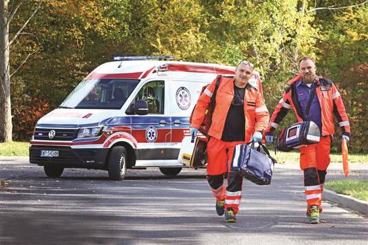 Dwóch ratowników medycznych  ze sprzętem w drodze.