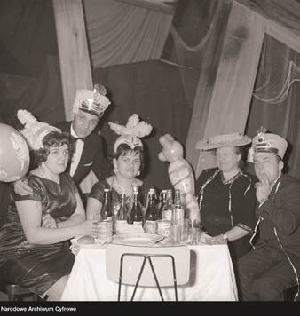 Pięć osób przy stole podczas zabawy karnawałowej.