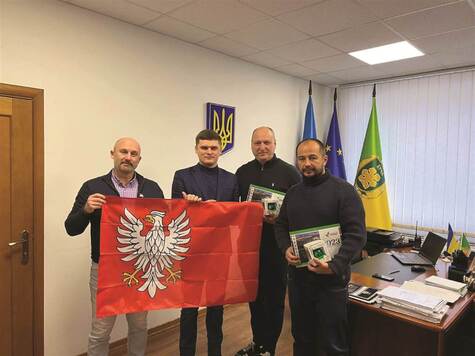 Czterech mężczyzn z flagą Mazowsza.