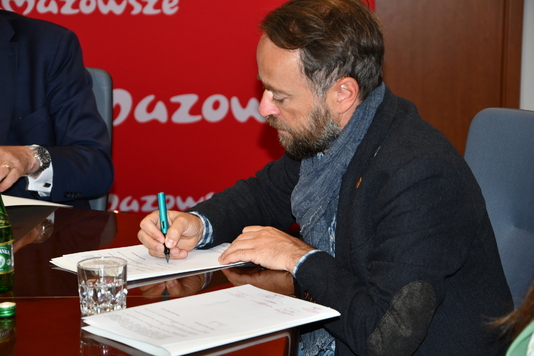 Wiceprezydent Warszawy podpisuje porozumienie.