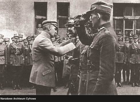 Józef Piłsudski przypina medal do piersi oficera