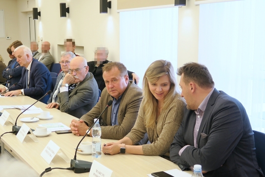 Członkowie komisji i samorządowcy z gminy Nieporęt siedzą przy stole.
